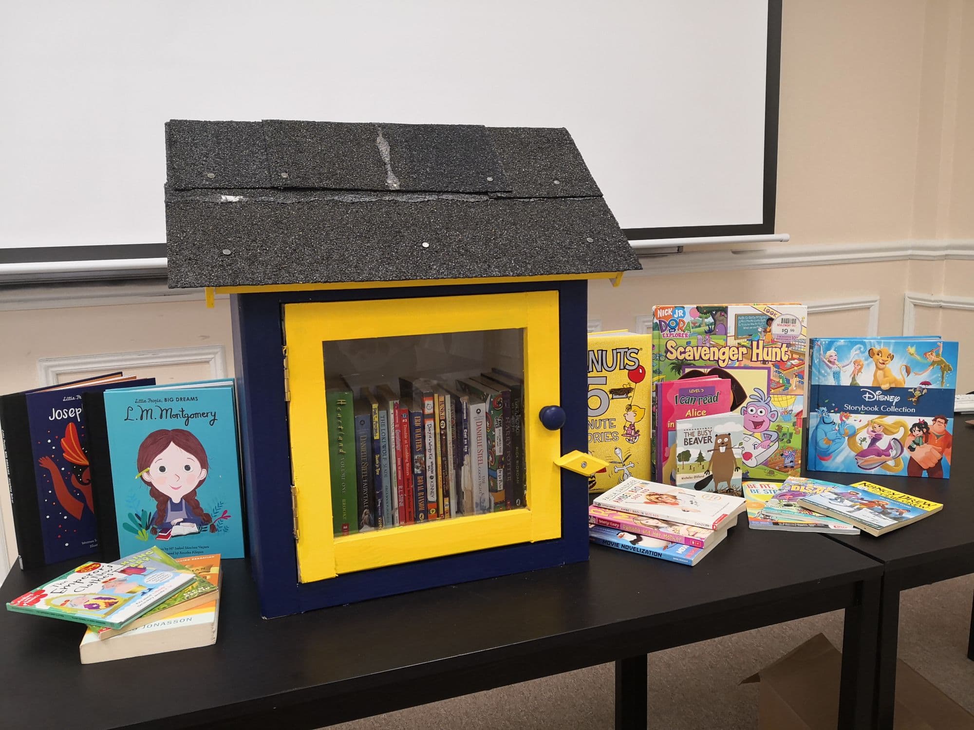 Elis Academy Little Library — a navy and yellow book house filled with donated children's books